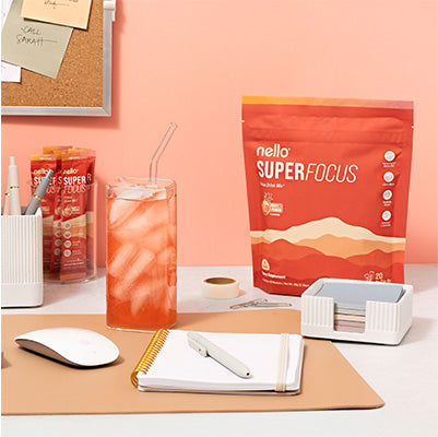 Desk setup with a drink, notebooks, and a package labeled 'Super Focus.'