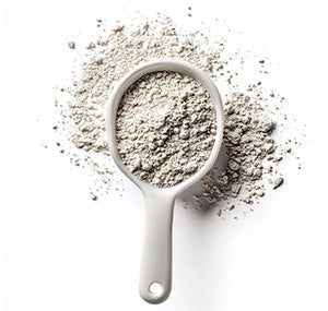 White measuring cup filled with grayish powder, against white background.