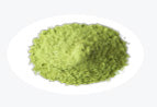 A small mound of green matcha powder on a white background.
