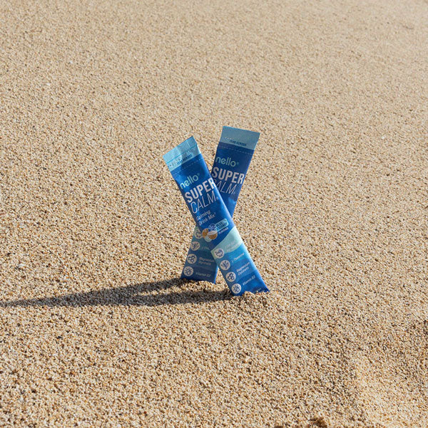 Two blue packets standing in sand.